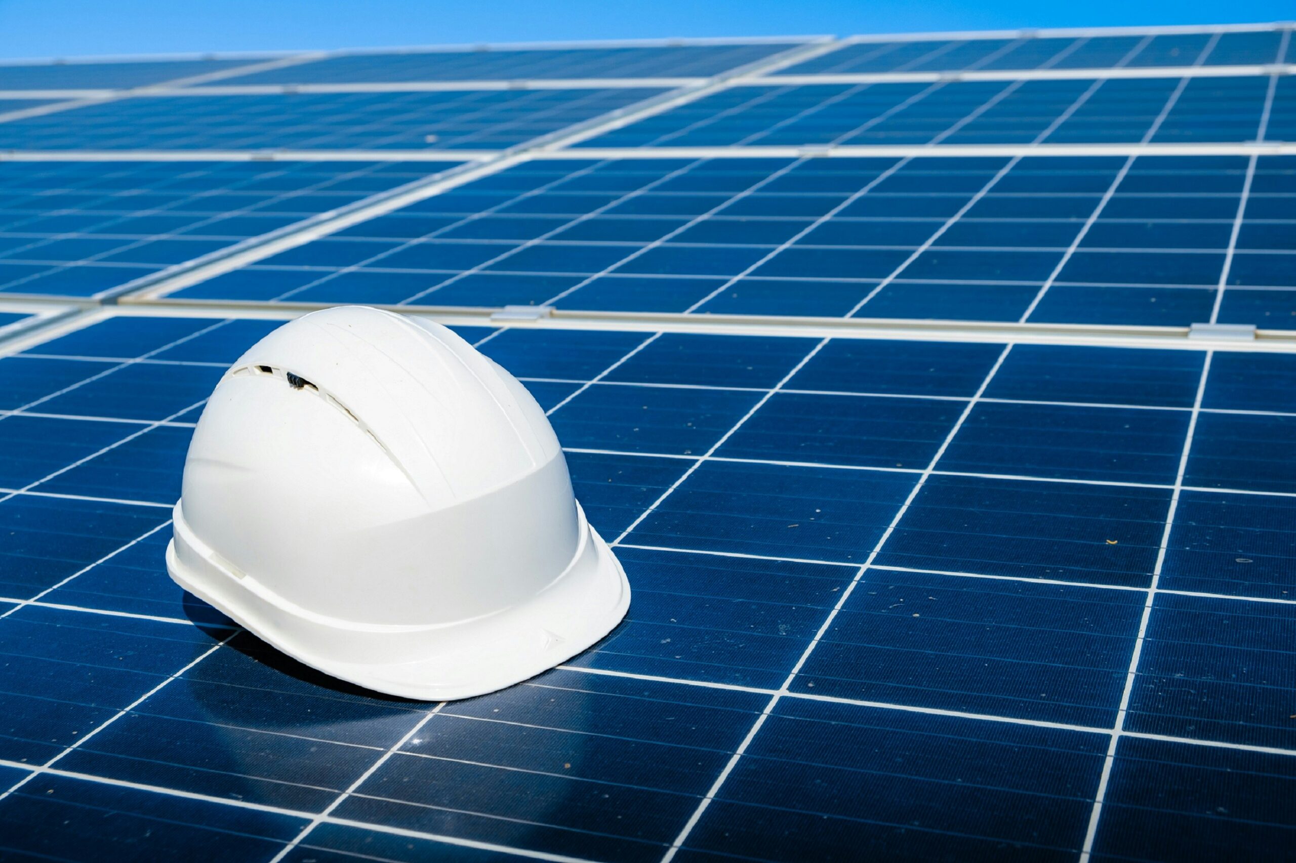 Photovoltaikanlage mit weißem Helm darauf liegend
