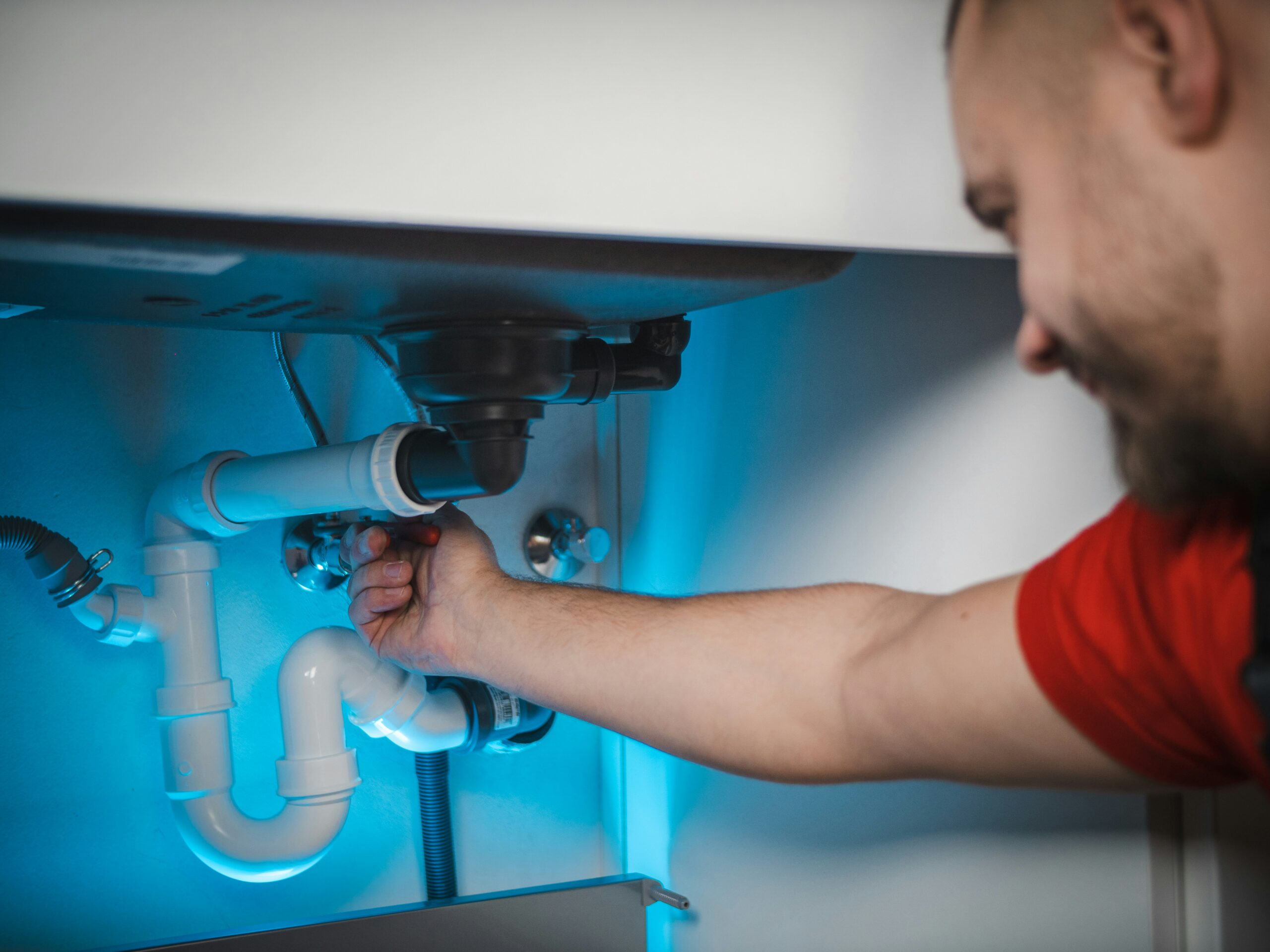 Ein Klempner bei der Installation unter einem Waschbecken